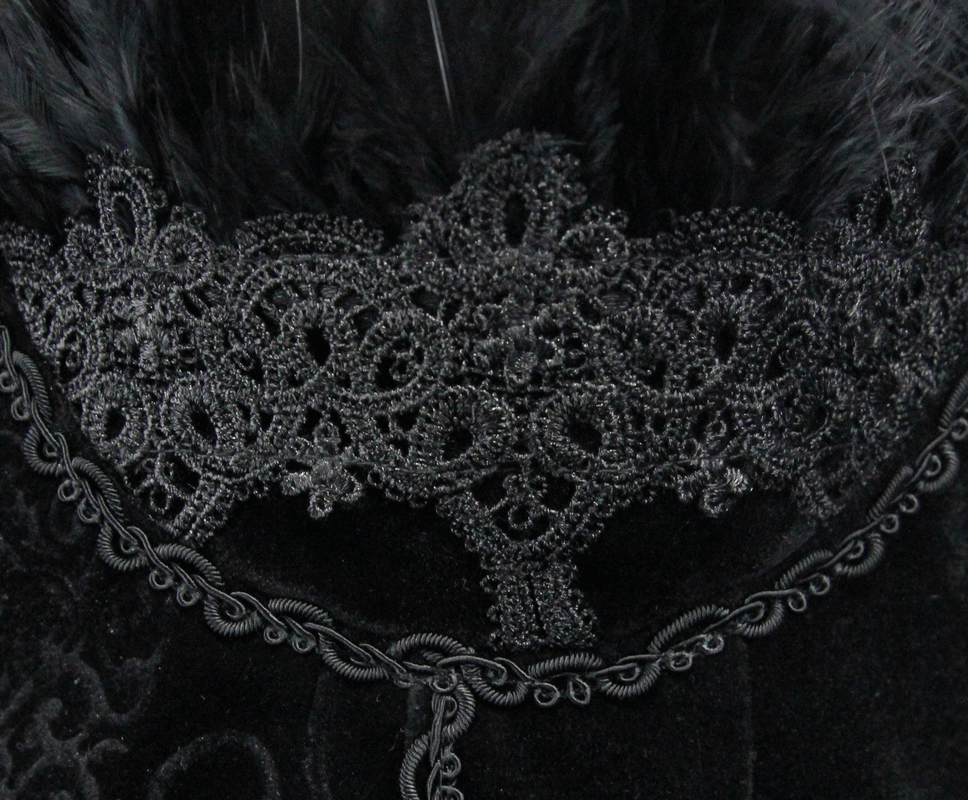 Close-up of intricate black lace trim and feather detail on a steampunk dress, showcasing elegant gothic fashion.