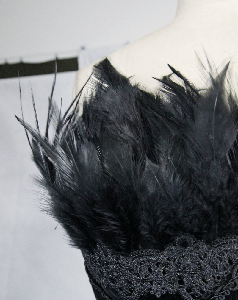 Close-up of black dress back with feathered embellishments and lace trim, perfect for steampunk style.