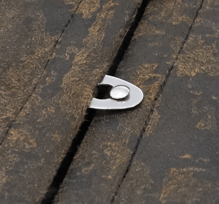 Close-up of a bronze rivet on a vintage brown steampunk vest made of PU leather.