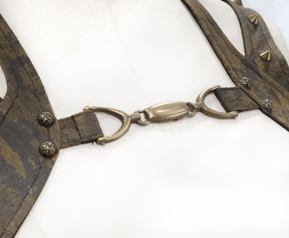 Close-up of steampunk vest detail showcasing bronze rivets and unique metal clasp on a vintage brown PU leather design.