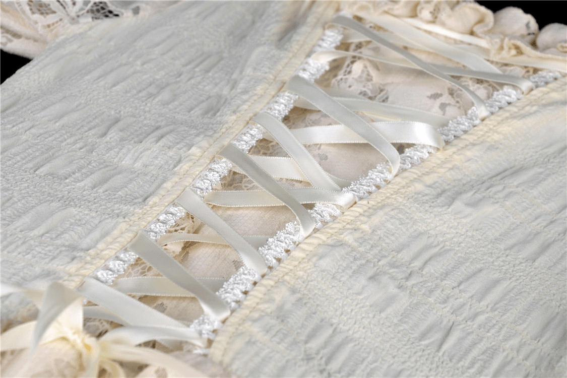 Close-up of lace and ribbon detailing on a vintage off-shoulder dress, showcasing steampunk-inspired design.