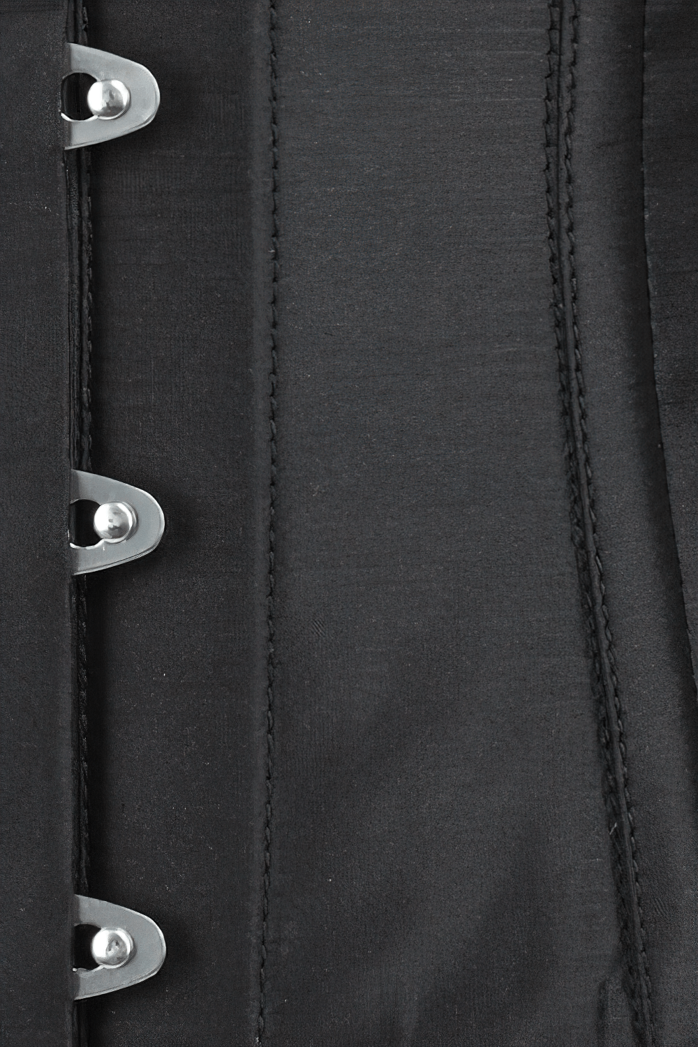 Close-up of a black steel boned waist trainer with busk closure, showcasing the structured design and detailed stitching.