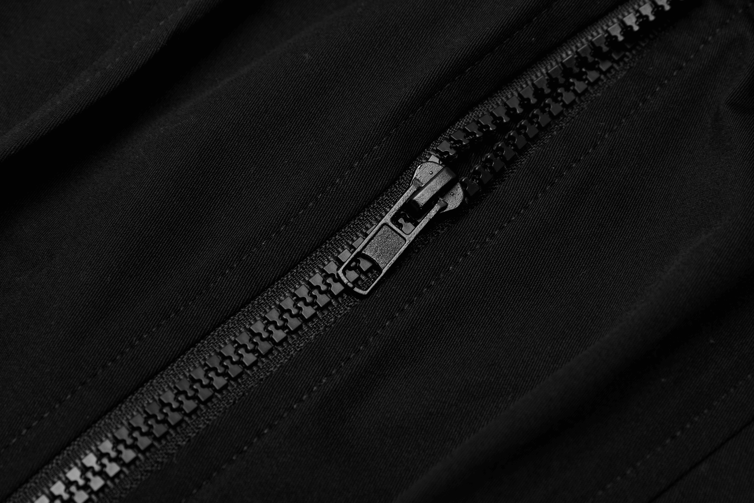 Close-up of a black zipper on a tactical skirt, showcasing its edgy and functional design.