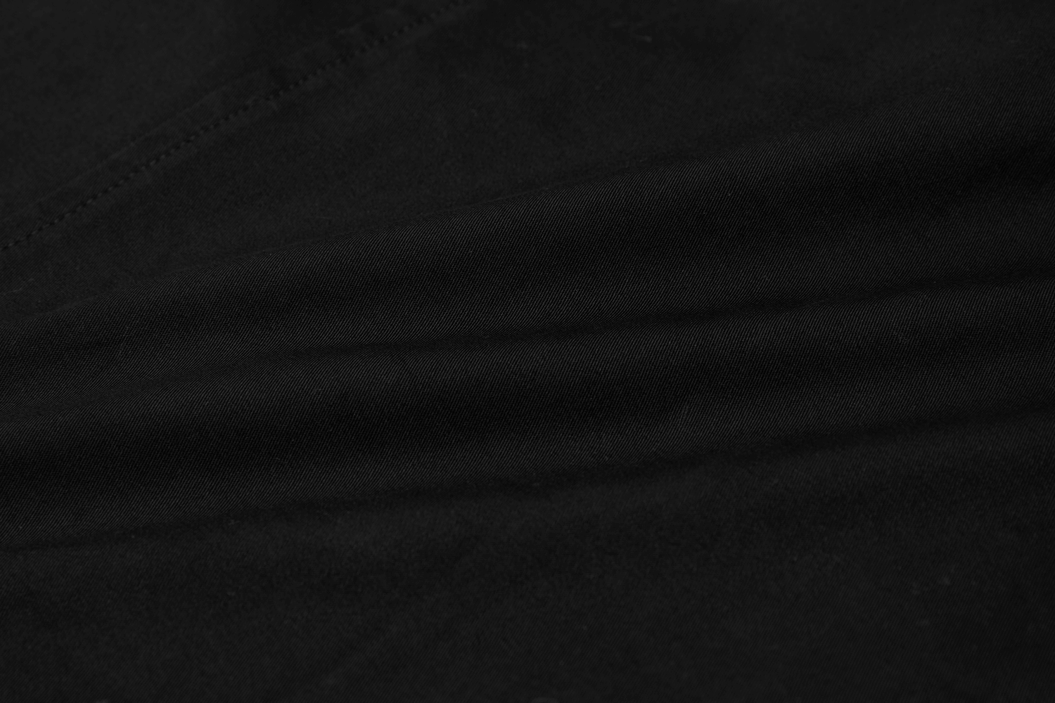 Close-up of the black fabric texture of the Street-Ready Asymmetric High Waist Tactical Skirt, showcasing its durability.