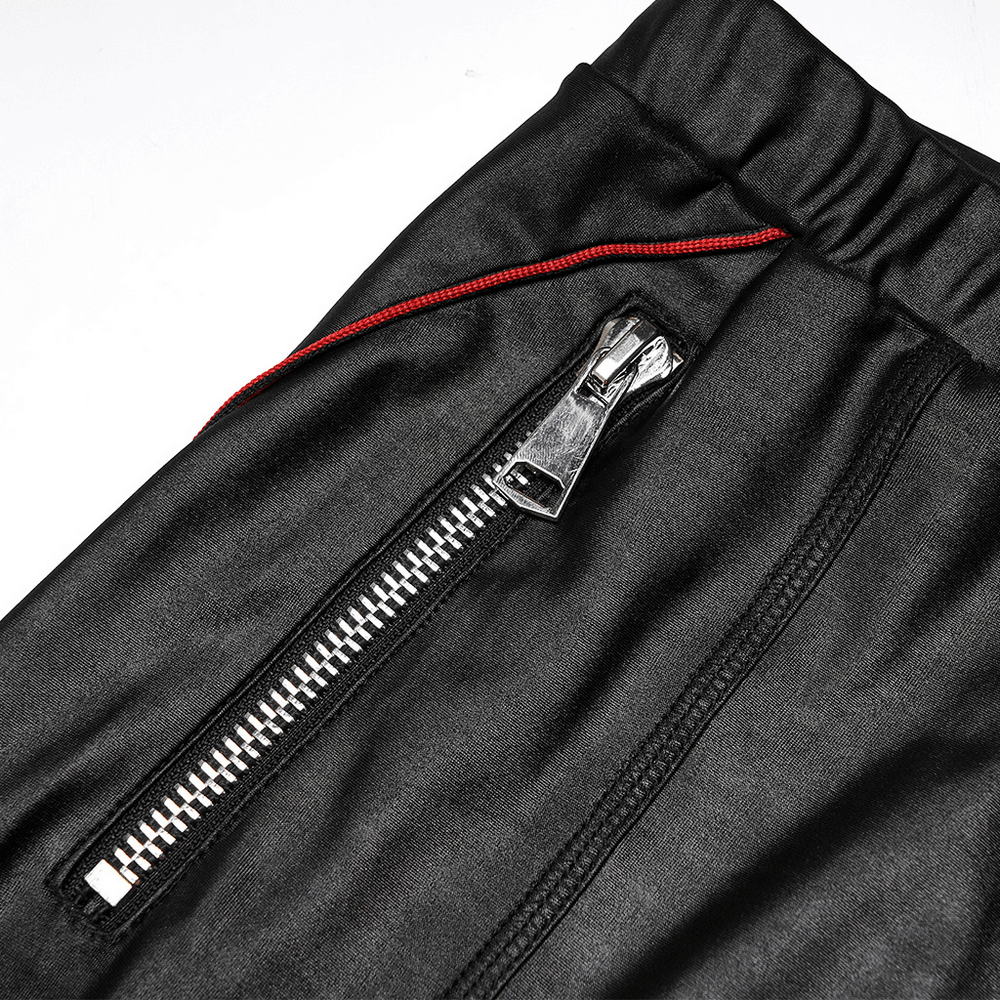 Close-up of stretch faux leather pants featuring edgy zip detail and contrasting red stitching for a chic punk style.