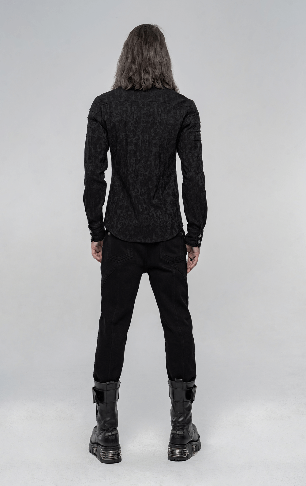 Back view of a man in a black Stretch Jacquard Gothic Shirt with unique button detail, styled with punk black pants and boots.