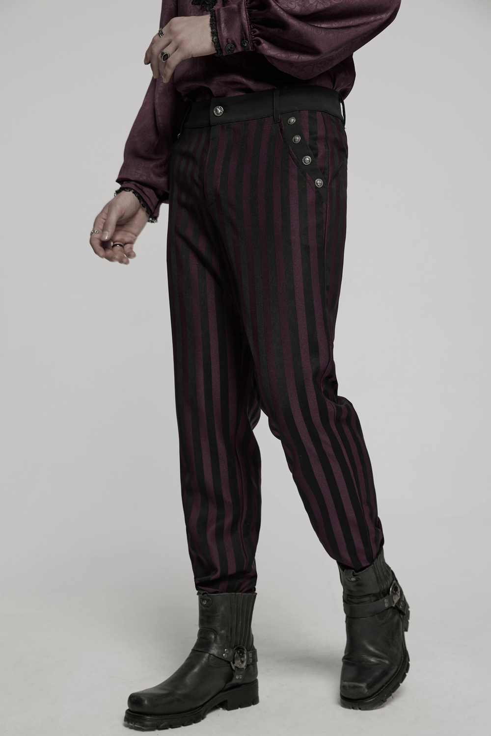 Striped black and burgundy slim gothic trousers showcased on model with stylish black boots.