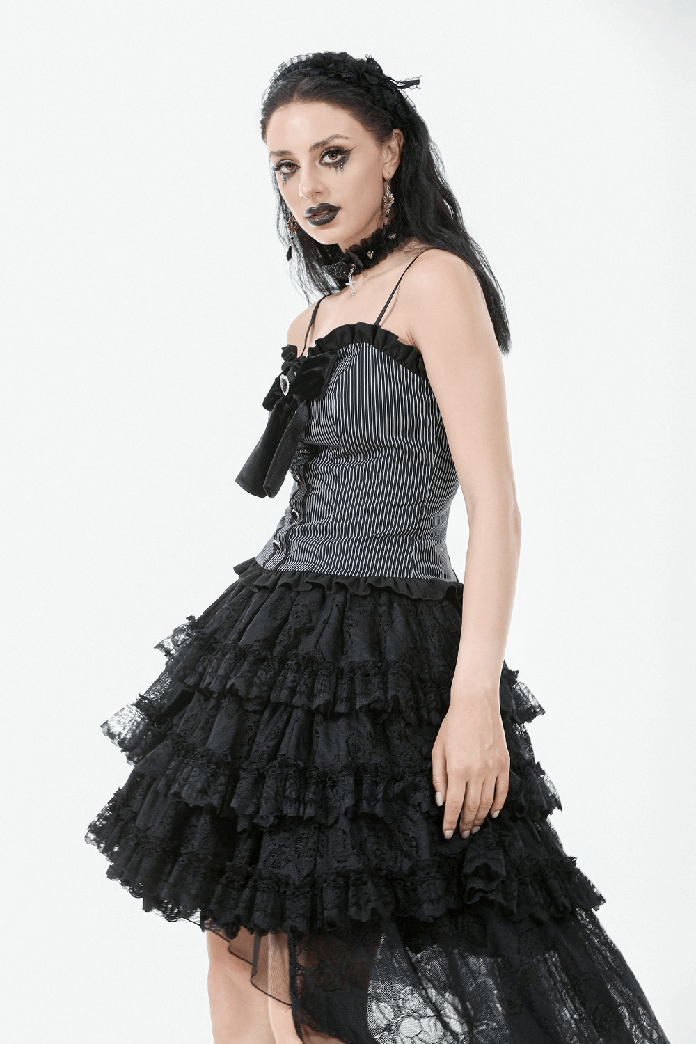 Elegant model in a black and white striped top with heart bow and lace skirt, showcasing vintage-inspired fashion.