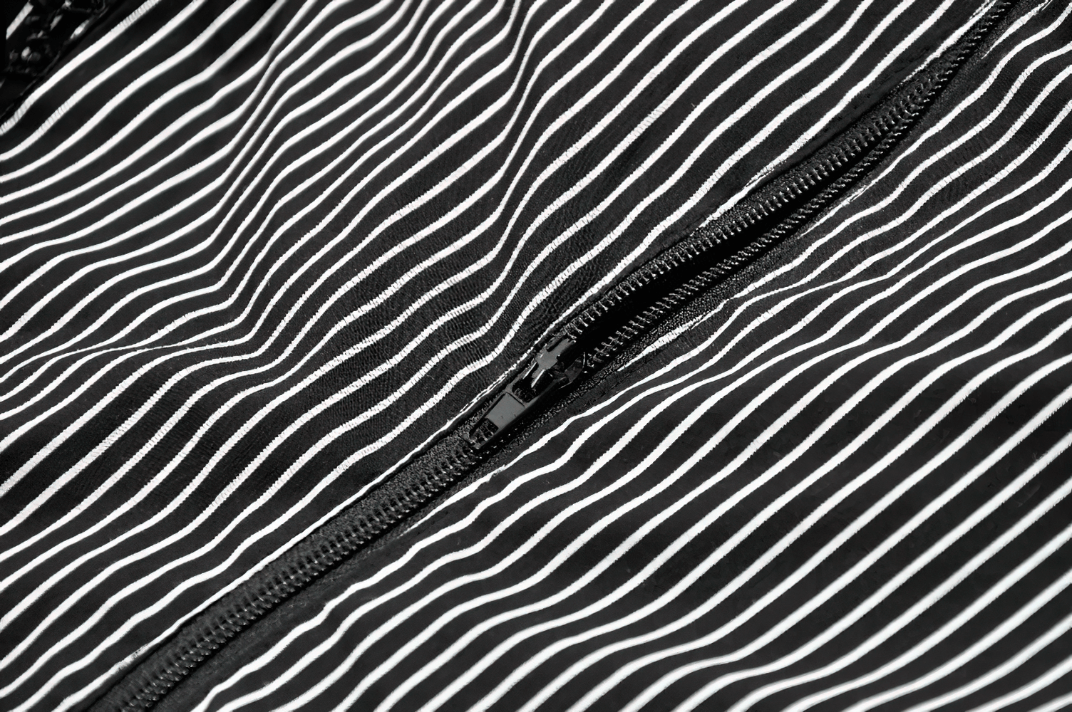 Close-up of black and white striped fabric showcasing a zipper detail for stylish top design.