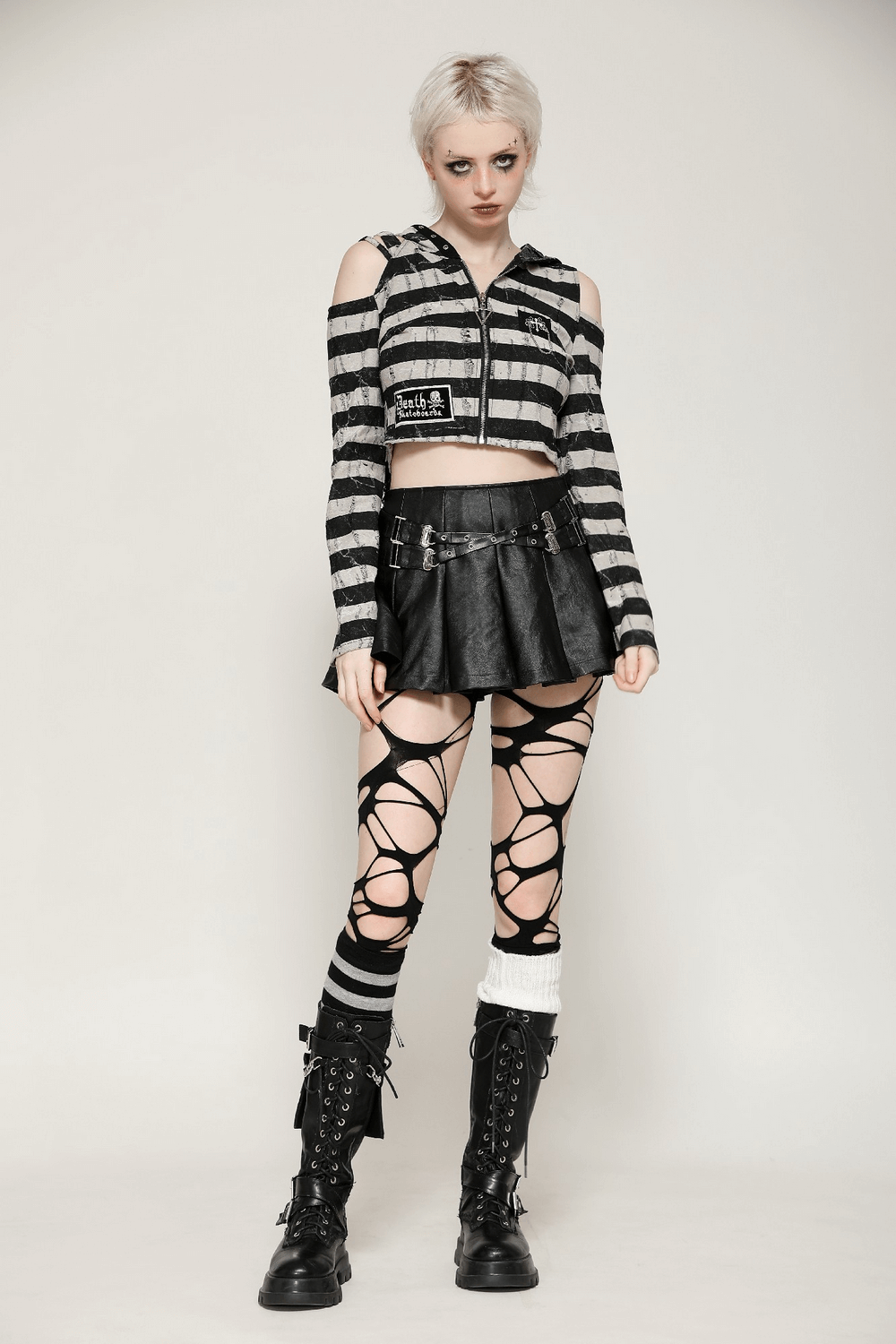 Model wearing a striped bunny hooded crop top with black leather skirt and edgy accessories in gothic Lolita style.