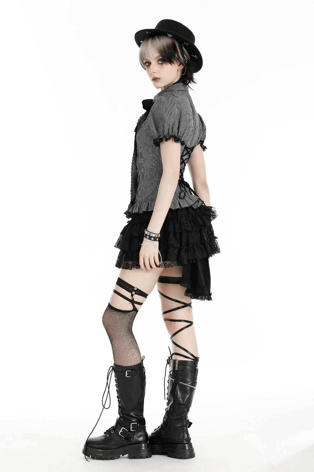 Model wearing a striped Gothic blouse with bow and lace details, paired with a ruffled skirt and stylish boots.