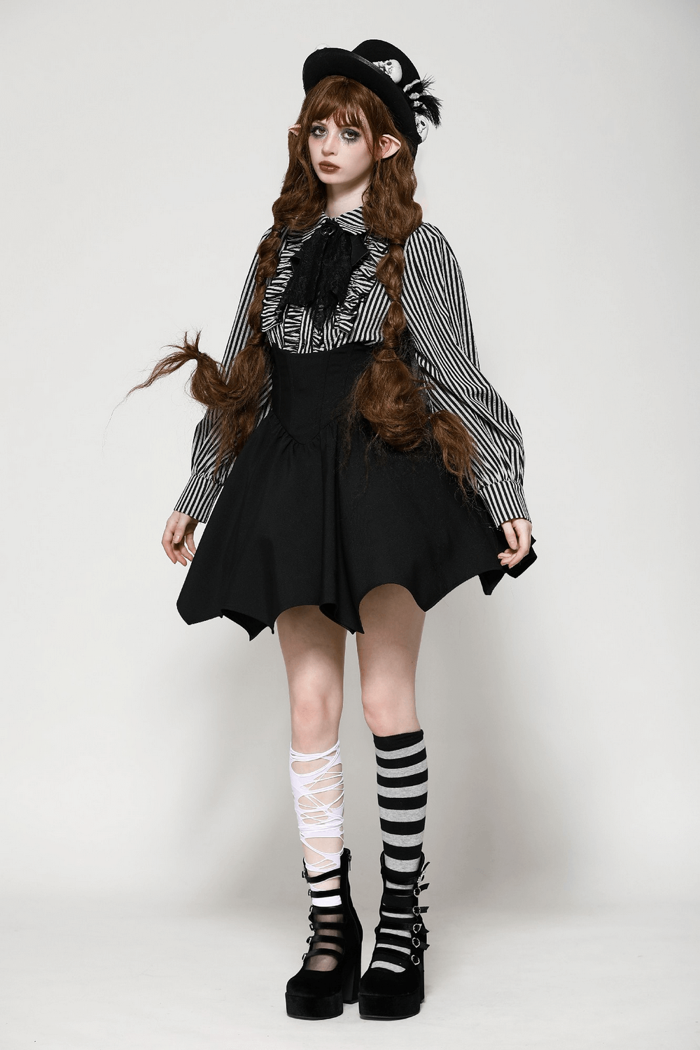 Women's gothic fashion featuring a striped blouse with ruffles, bat-shaped skirt, and lace-up platform shoes.