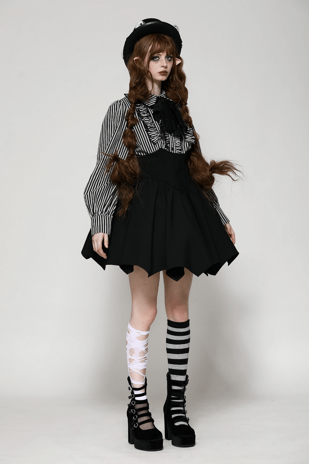 Striped gothic blouse with lace details, ruffled sleeves, and black skirt, paired with striped knee socks and platform shoes.