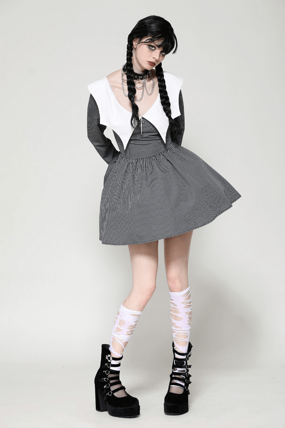 Chic black and white dress with unique collar, styled with braided hair and platform heels for a fashionable look.