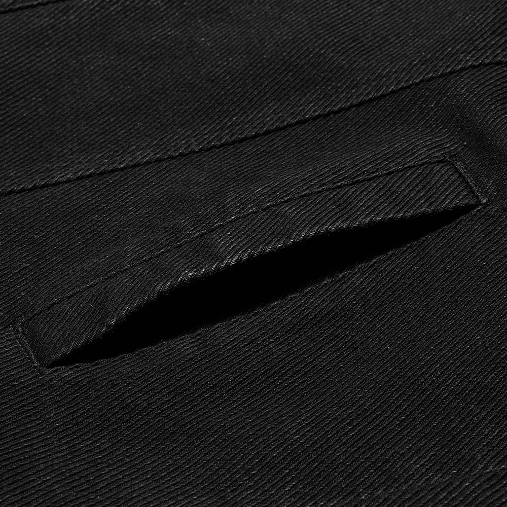 Close-up of a pocket detail on a studded black denim jacket, showcasing the rugged fabric texture.