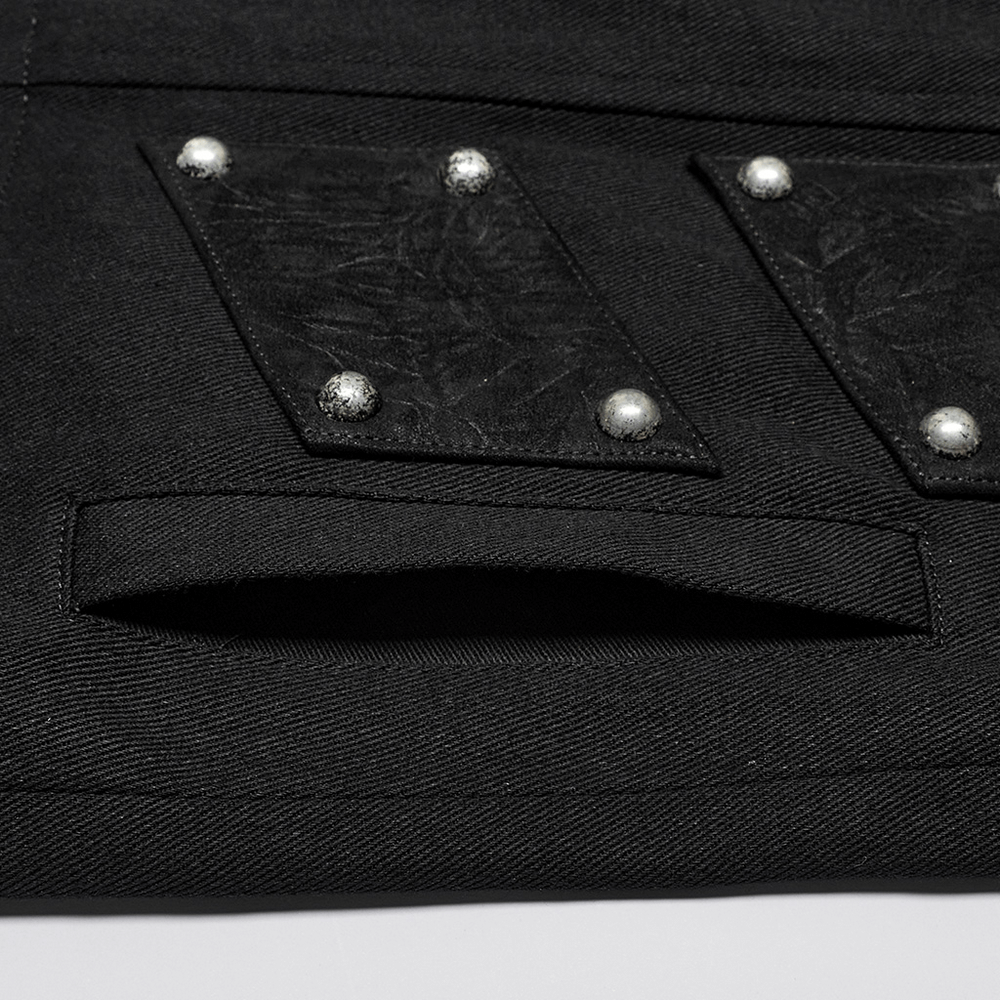 Close-up of black punk vest's suede patches and silver rivets, showcasing its edgy urban gothic design.