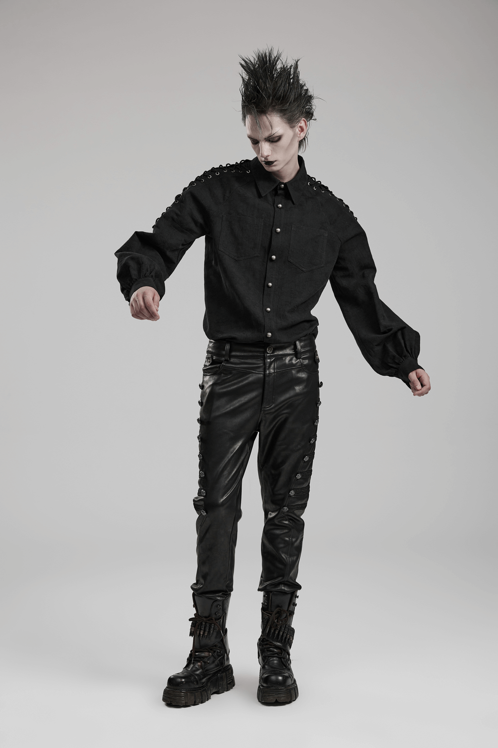 Model showcasing edgy studded side-buttoned PU punk rocker pants in gothic style.