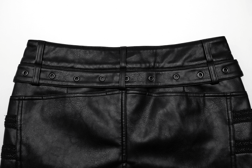 Close-up of punk rocker pants featuring studded side buttons and a sleek black leather texture for a gothic style.