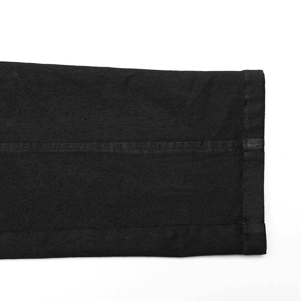 Close-up of the hem of studded waist slim-fit gothic PUNK denim pants, showcasing black denim fabric and stitching details.