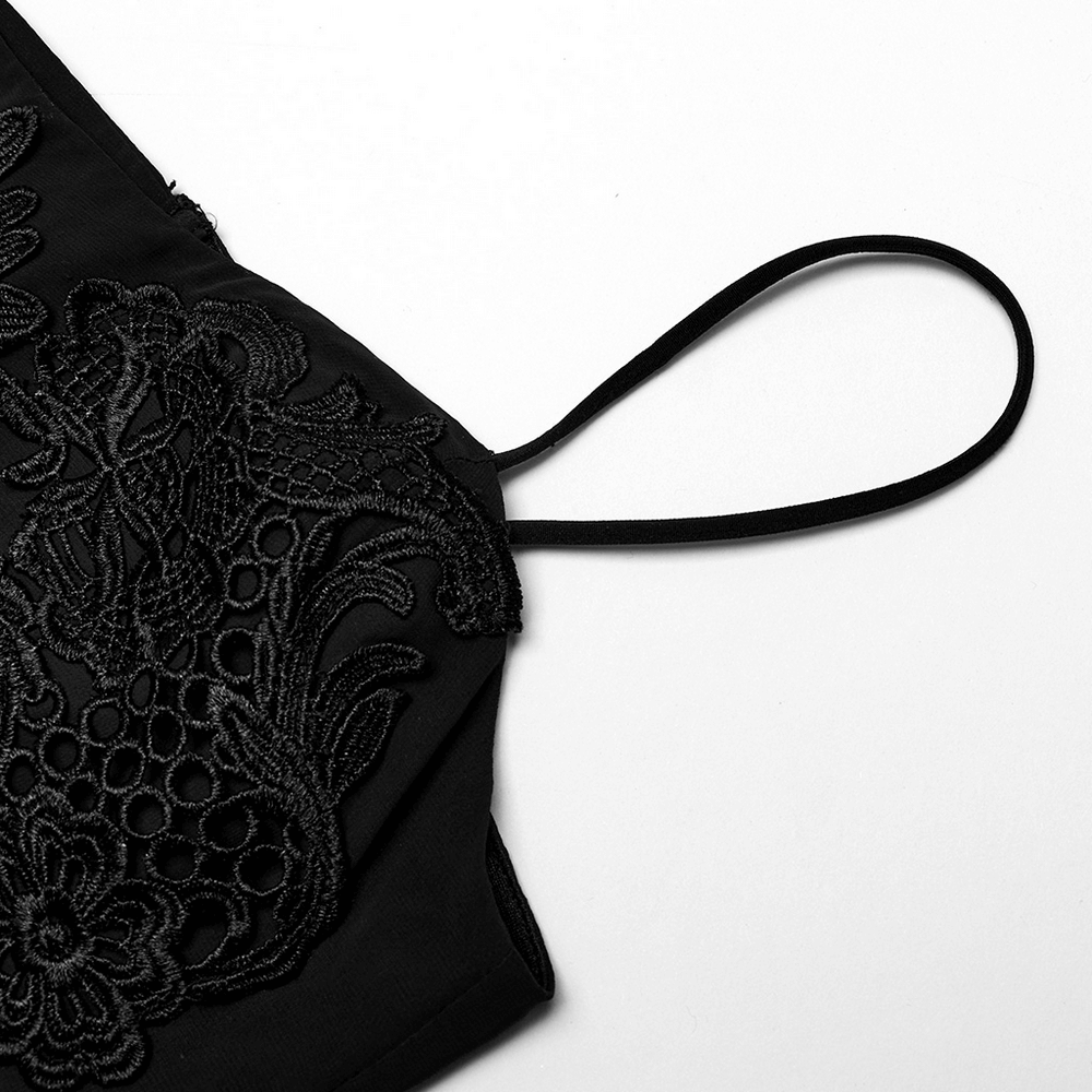 Elegant black dress detail featuring adjustable straps and intricate embroidery design.
