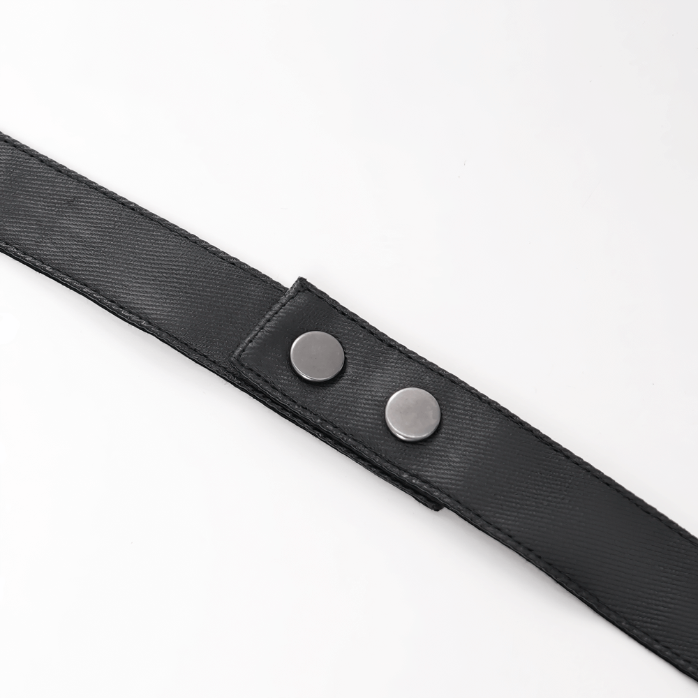 Close-up of a black fabric strap with two silver snap buttons, perfect for gothic fashion accessories.