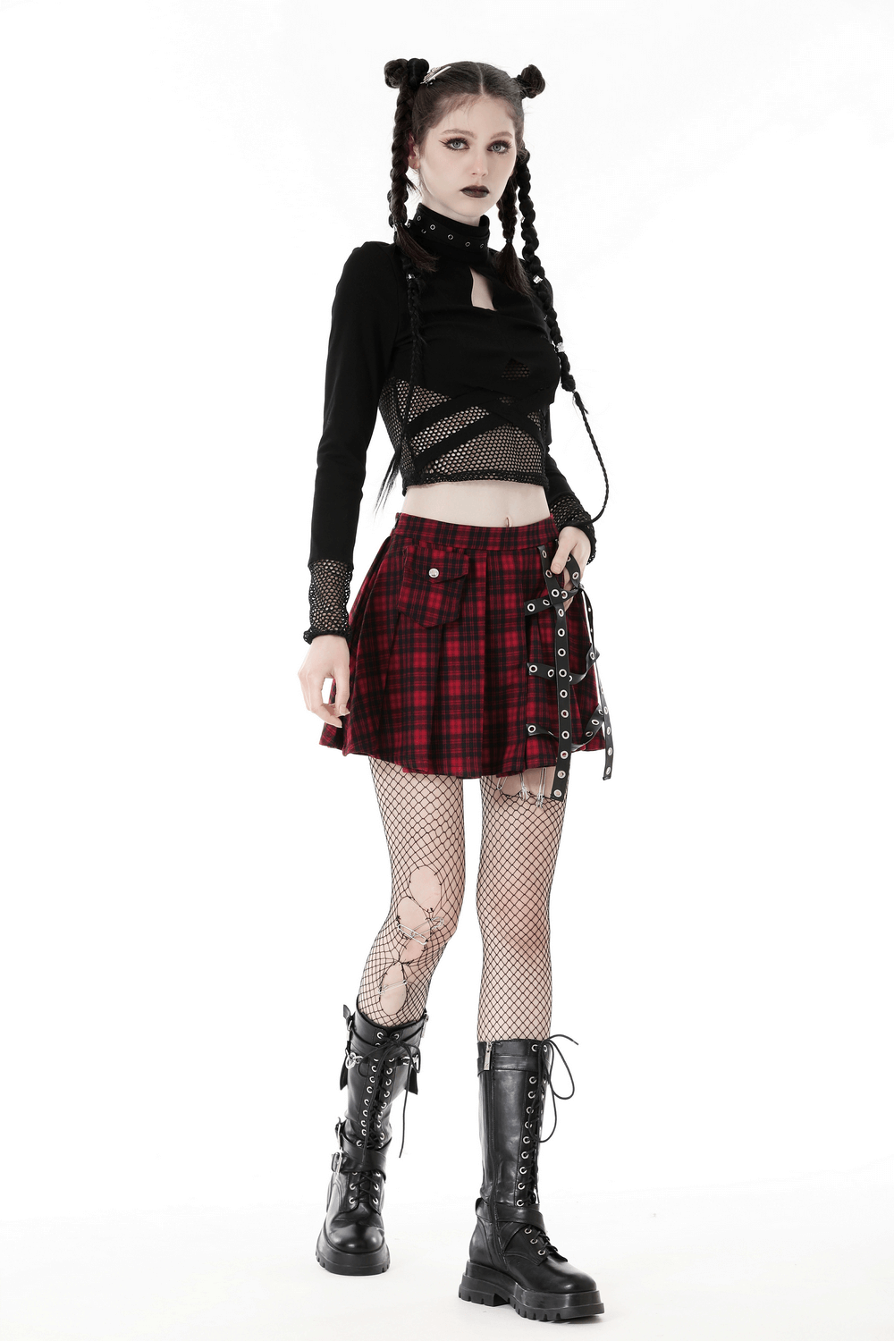 Edgy black crop top with cut-outs, paired with plaid skirt and fishnet tights, showcasing modern punk fashion.