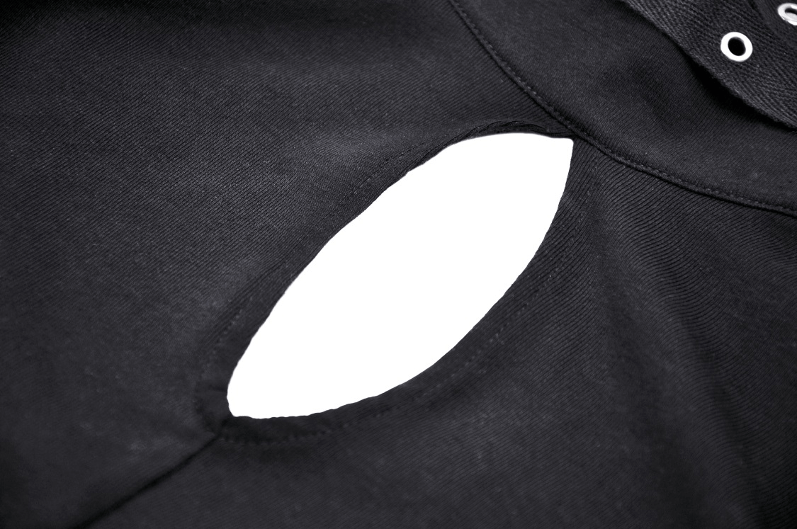 Close-up of stylish black top featuring edgy cut-out design, showcasing punk-inspired fashion details.