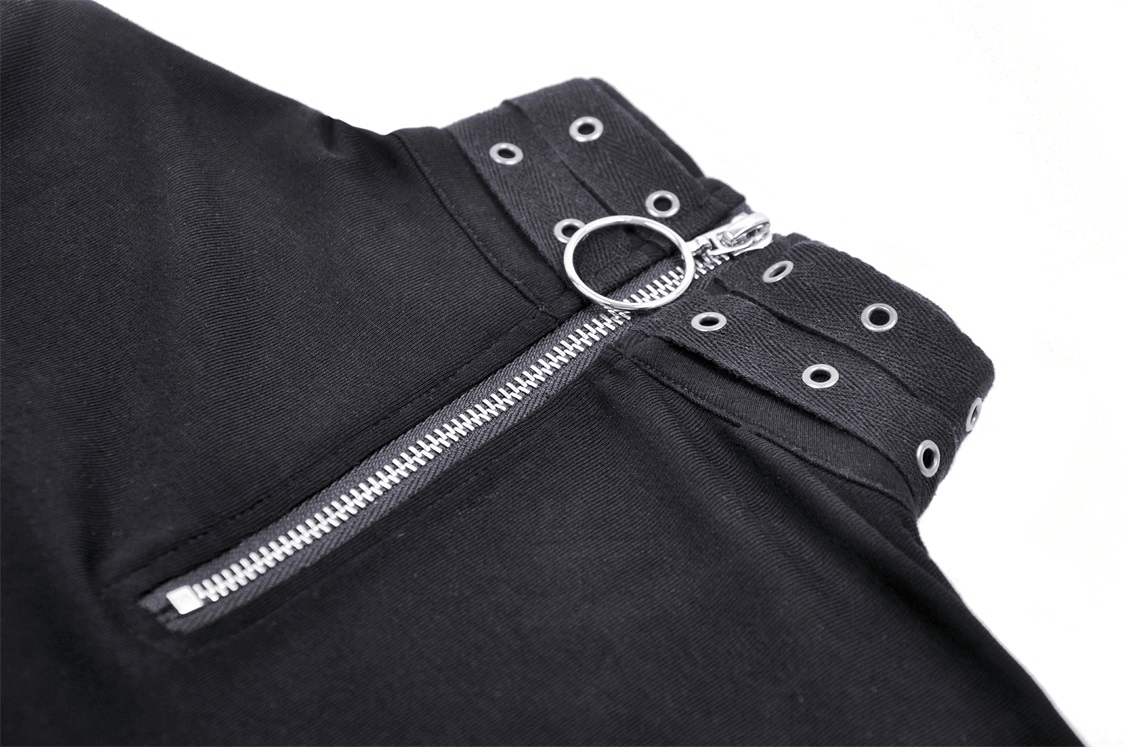 Close-up of stylish black pants featuring edgy ring zipper detail and grommet accents for a punk-inspired look.