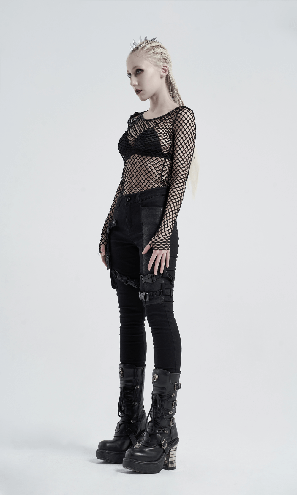 Stylish black mesh top with buckles, edgy punk vibe, shoulder cut-outs, paired with bold combat boots.