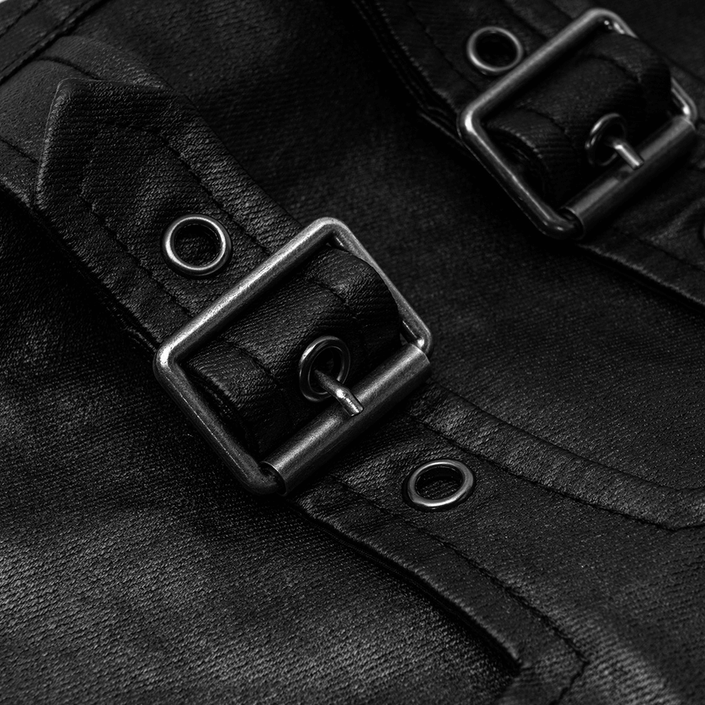 Close-up of stylish black faux leather pants featuring metal buckles and decorative zippers.