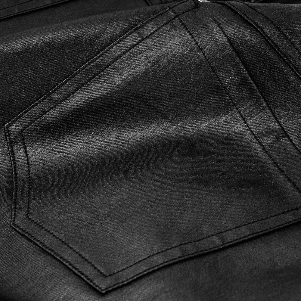 Close-up of black faux leather fabric with decorative stitching and pocket detailing for punk pants.