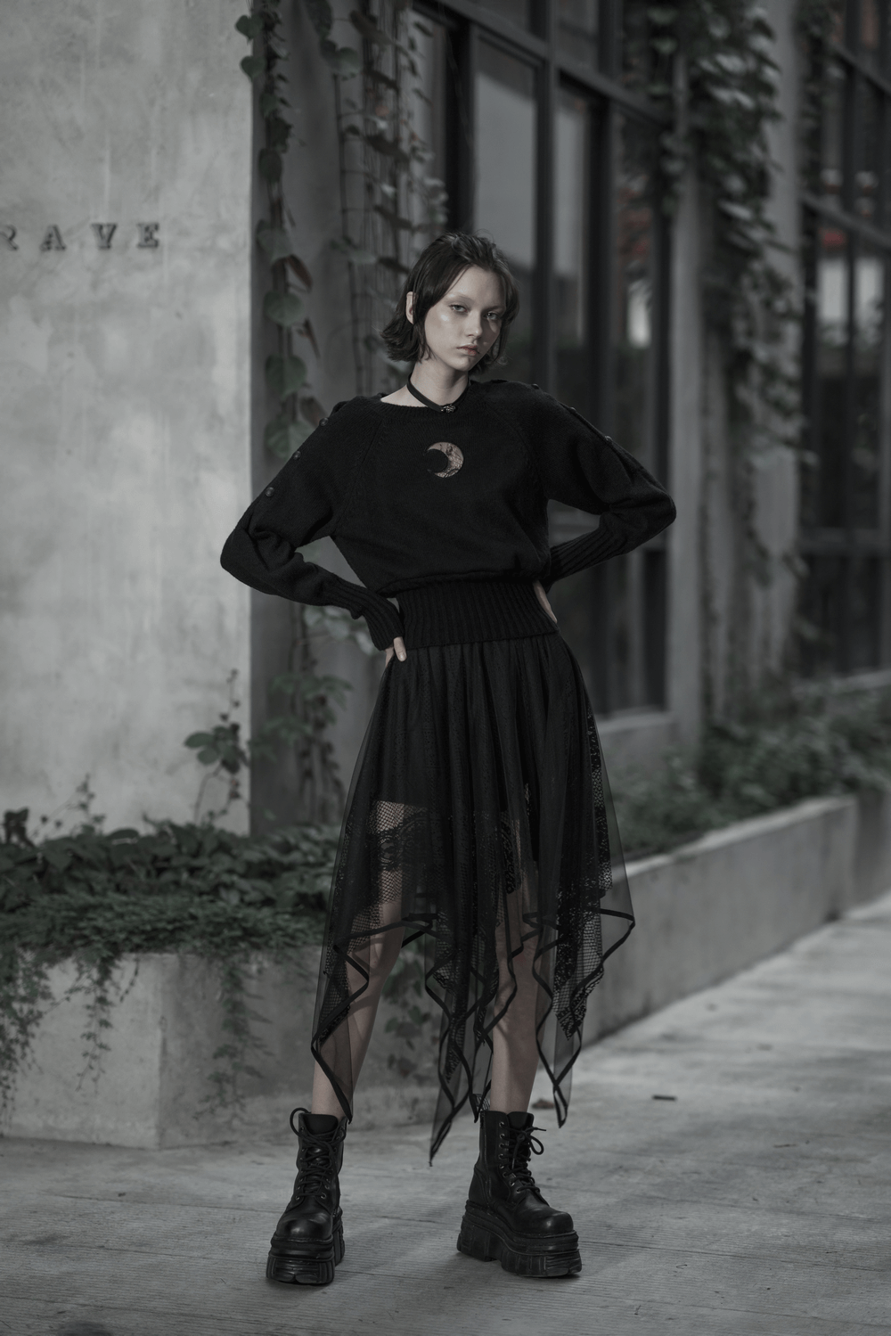 Model in a stylish black gothic layered mesh and lace skirt with an asymmetrical hem, showcasing edgy fashion.