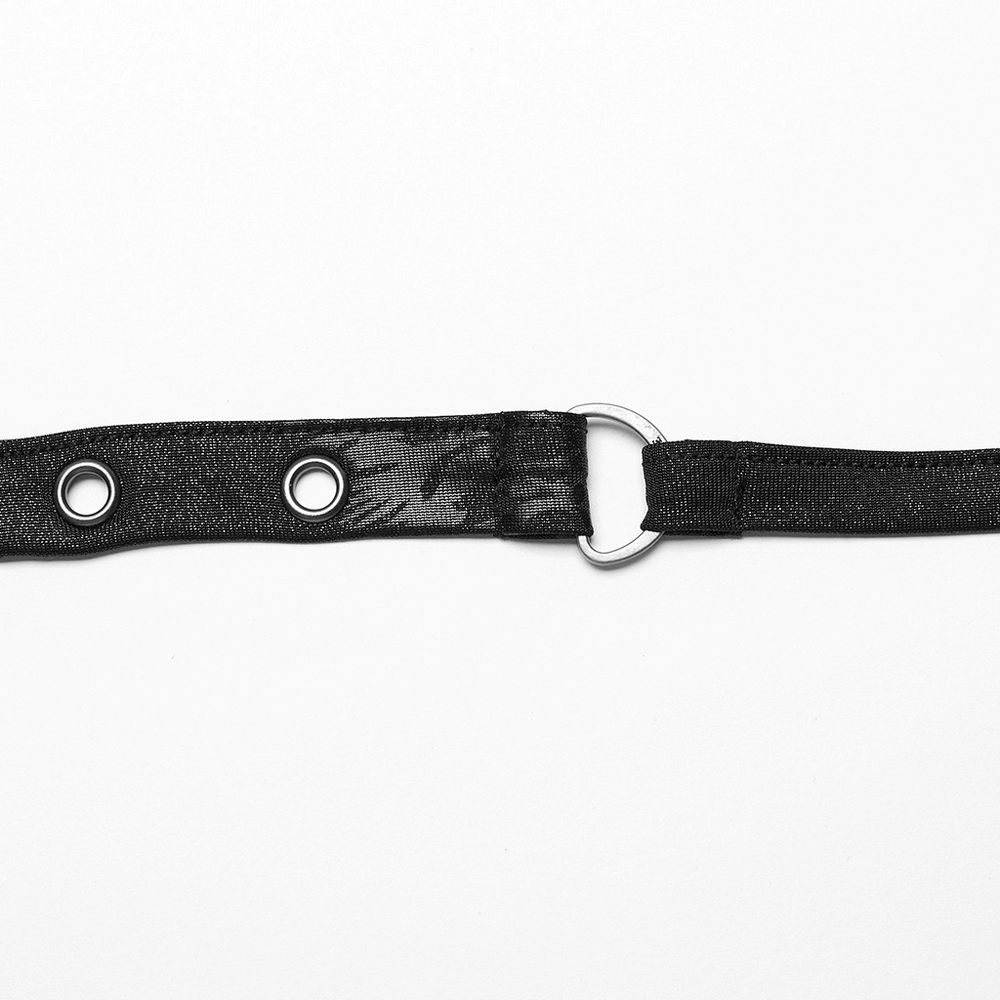 Close-up of a black halter top strap with eyelets and a metal ring for punk rock style fashion.