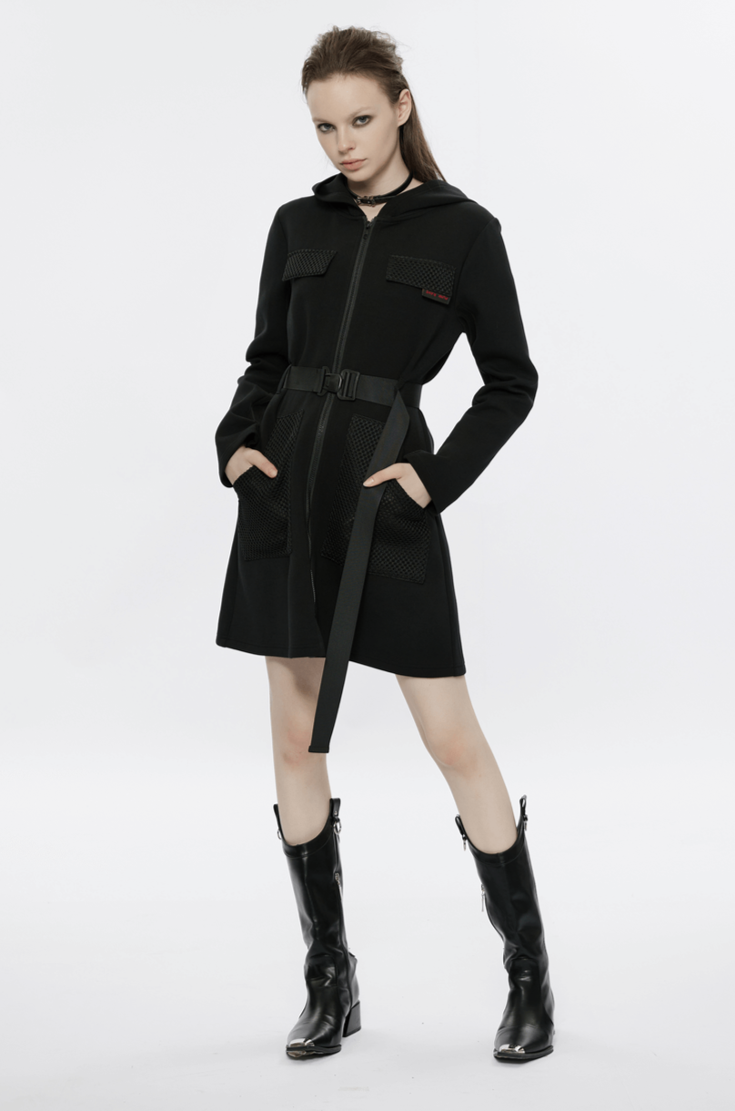 Model showcasing a stylish black hooded zip-front tactical dress with pockets and a belt.