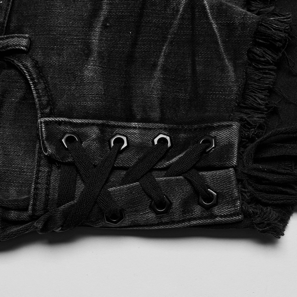Close-up of stylish black lace-up side detail on punk asymmetrical denim shorts showcasing edgy rivet design.