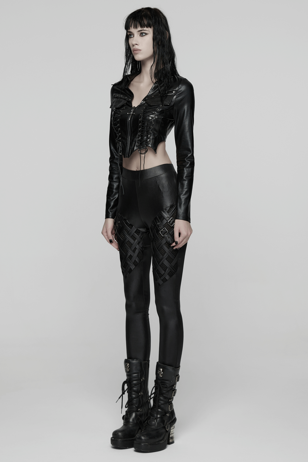 Stylish Black Leggings with Woven Cross and Buckle Detail worn with a chic cropped leather jacket and combat boots.
