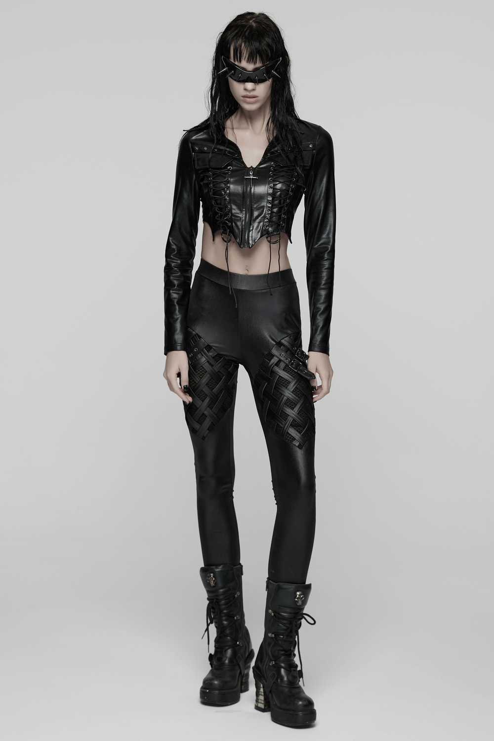 Stylish Black Leggings with Woven Cross and Buckle Detail worn by a model in a punk outfit with stylish black jacket.
