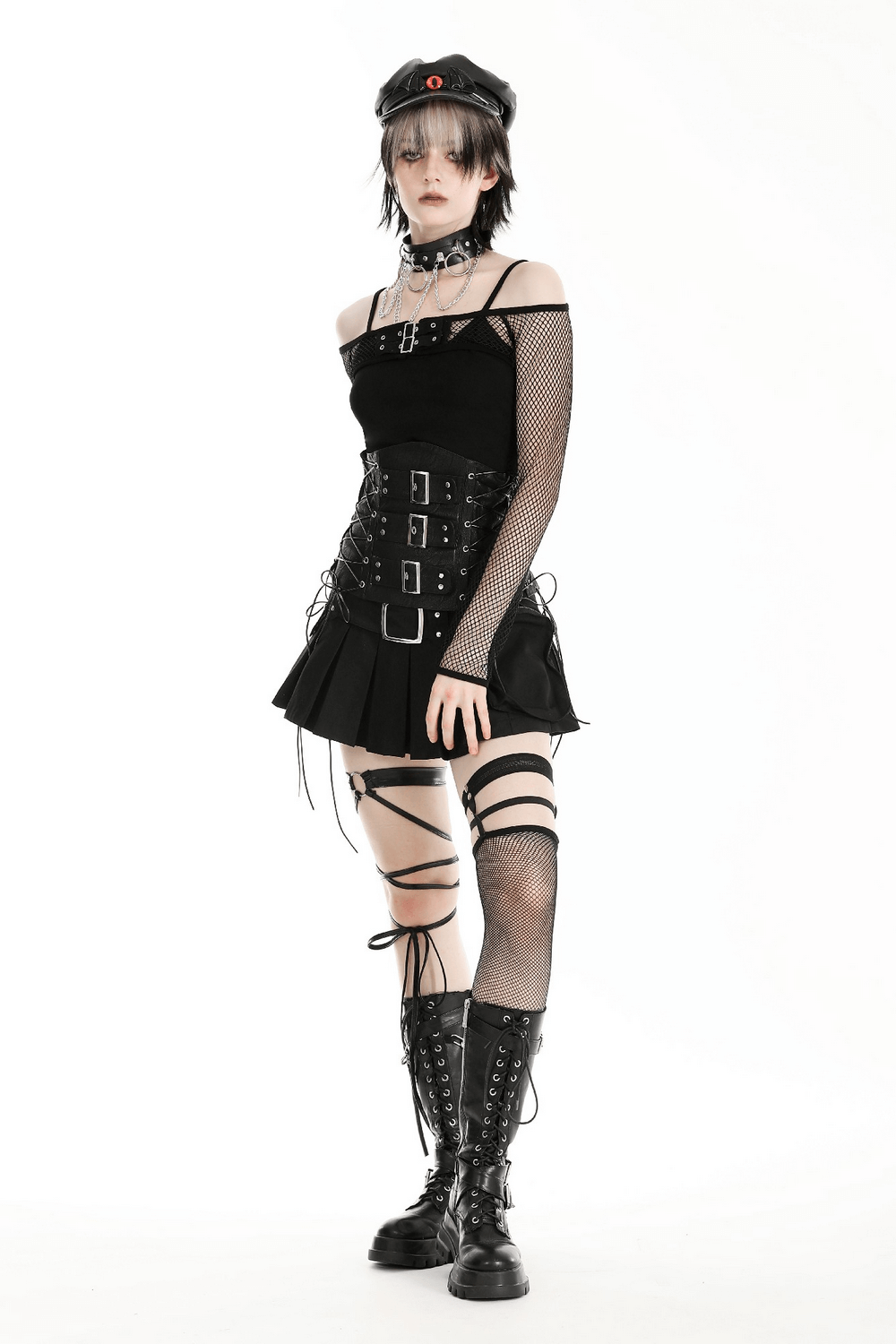 Model in stylish black long-sleeved fishnet top with buckles, paired with a black skirt and combat boots.