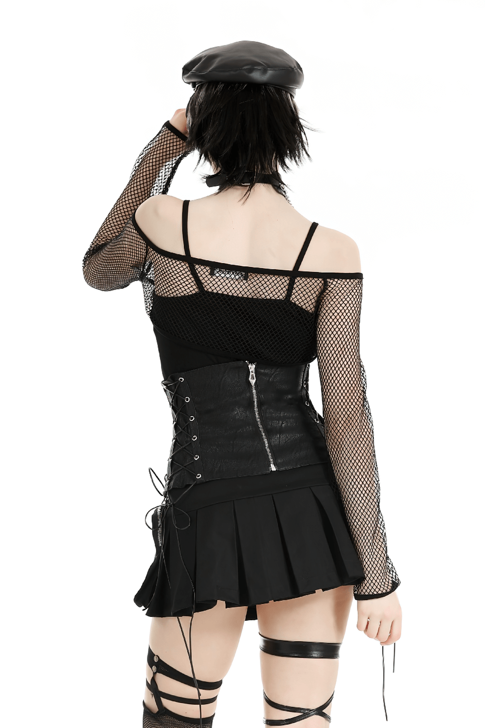 Back view of a stylish black fishnet top with buckles and a pleated skirt, showcasing an edgy fashion statement.