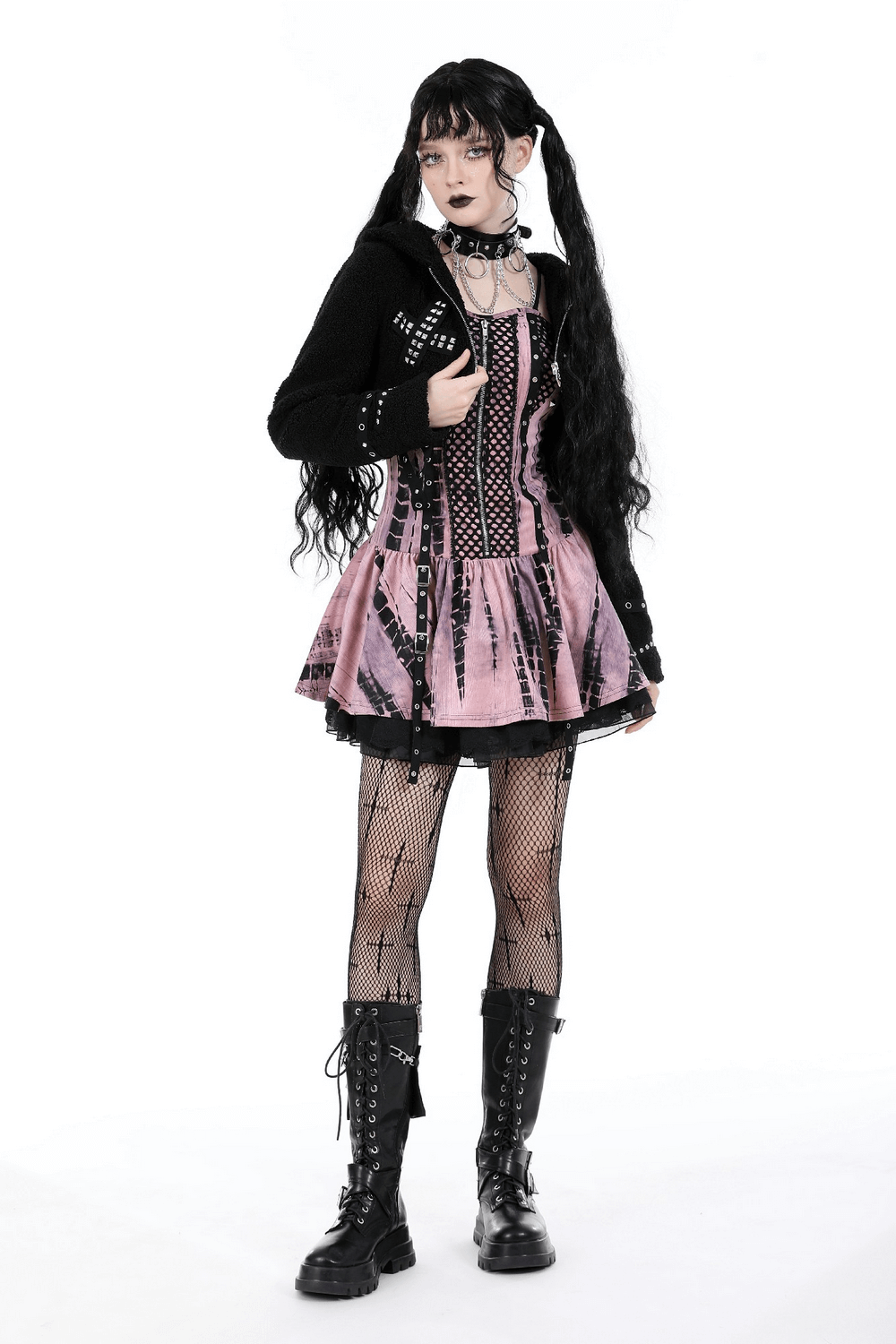 Fashionable model in a pink and black gothic outfit with fishnet stockings and knee-high boots.
