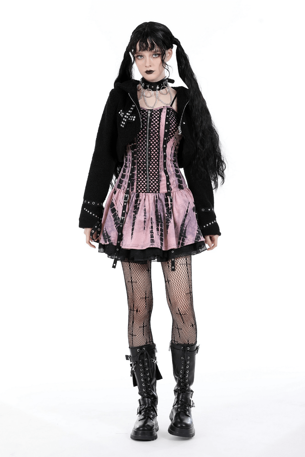 Goth-inspired model wearing a pink and black corset dress with fishnet tights and combat boots.