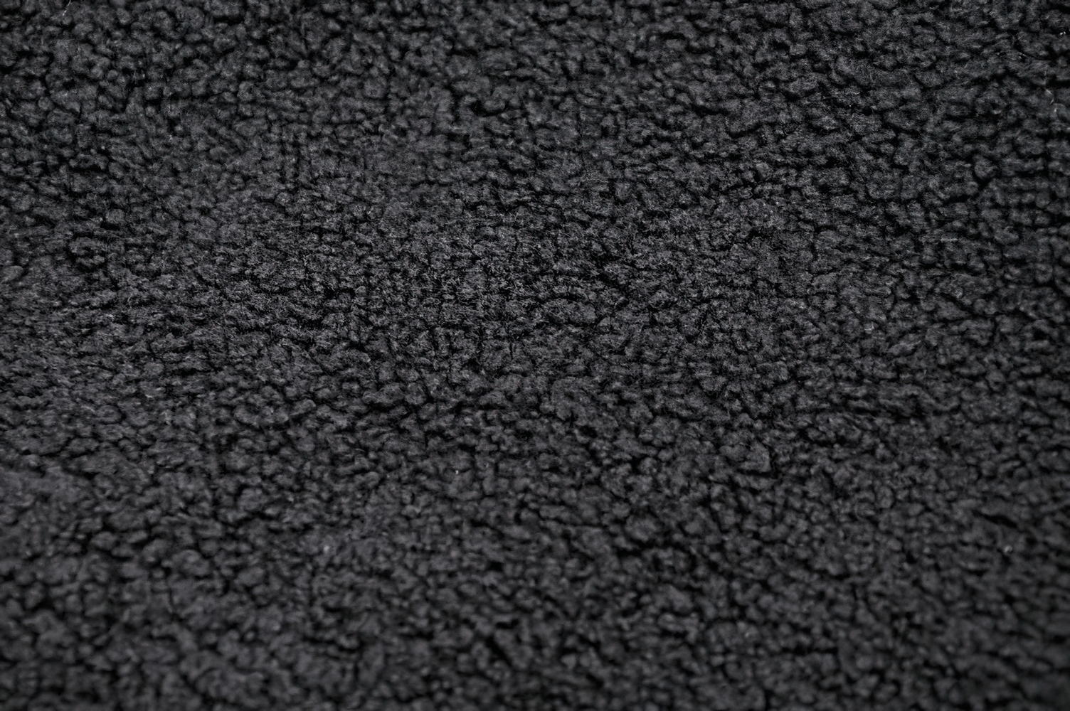 Close-up of soft fleece fabric in black, showcasing its unique texture and warmth.