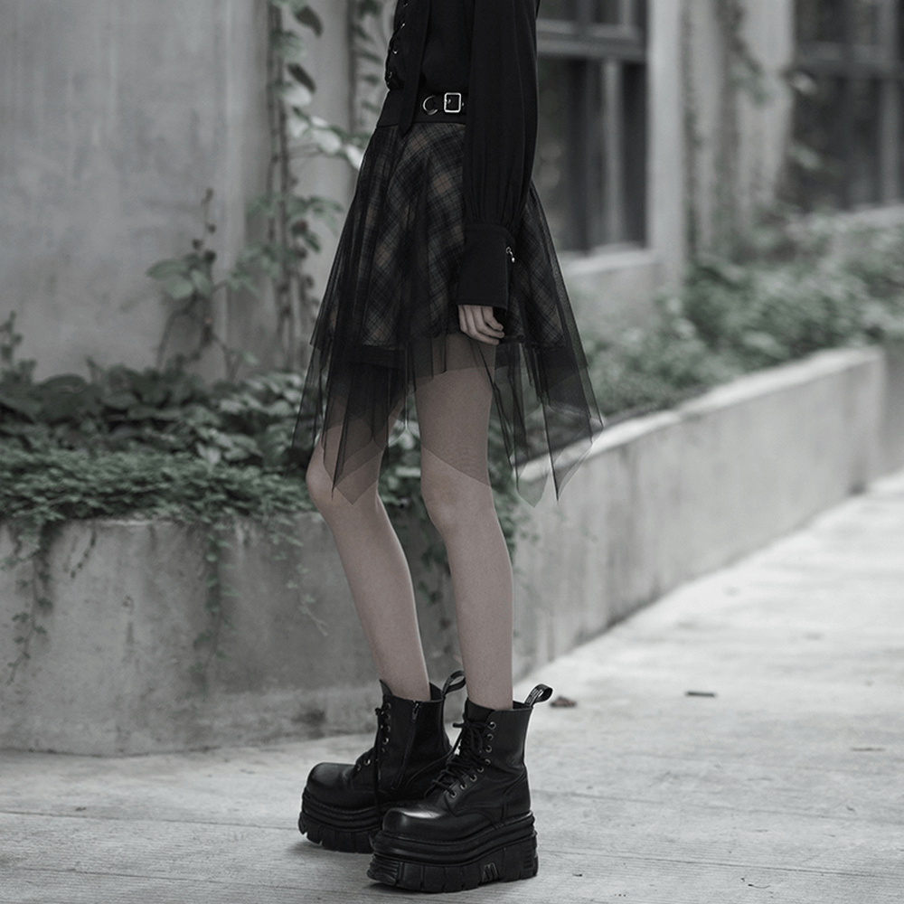 Stylish dark punk grunge plaid mesh asymmetric skirt paired with chunky black boots in an urban setting.