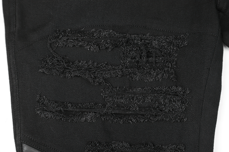 Close-up of distressed knee patches on edgy black punk trousers with textured detailing.