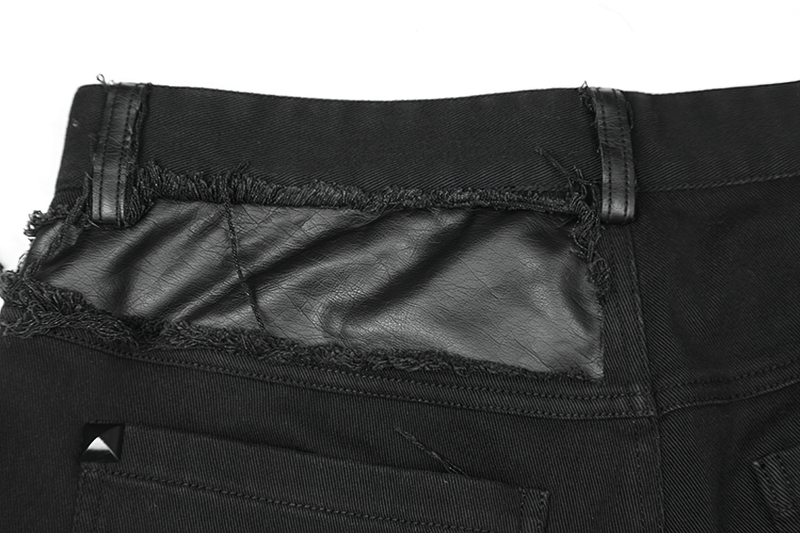 Close-up of the back of stylish distressed knee-patch punk trousers with leather patch and metallic studs.