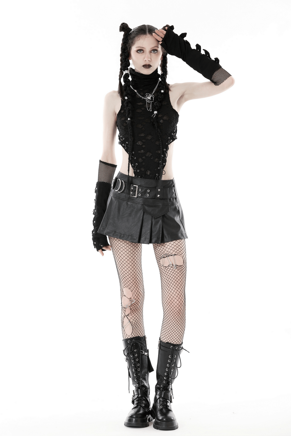 Gothic punk model wearing a stylish faux leather pleated mini skirt with buckle detail and edgy accessories.