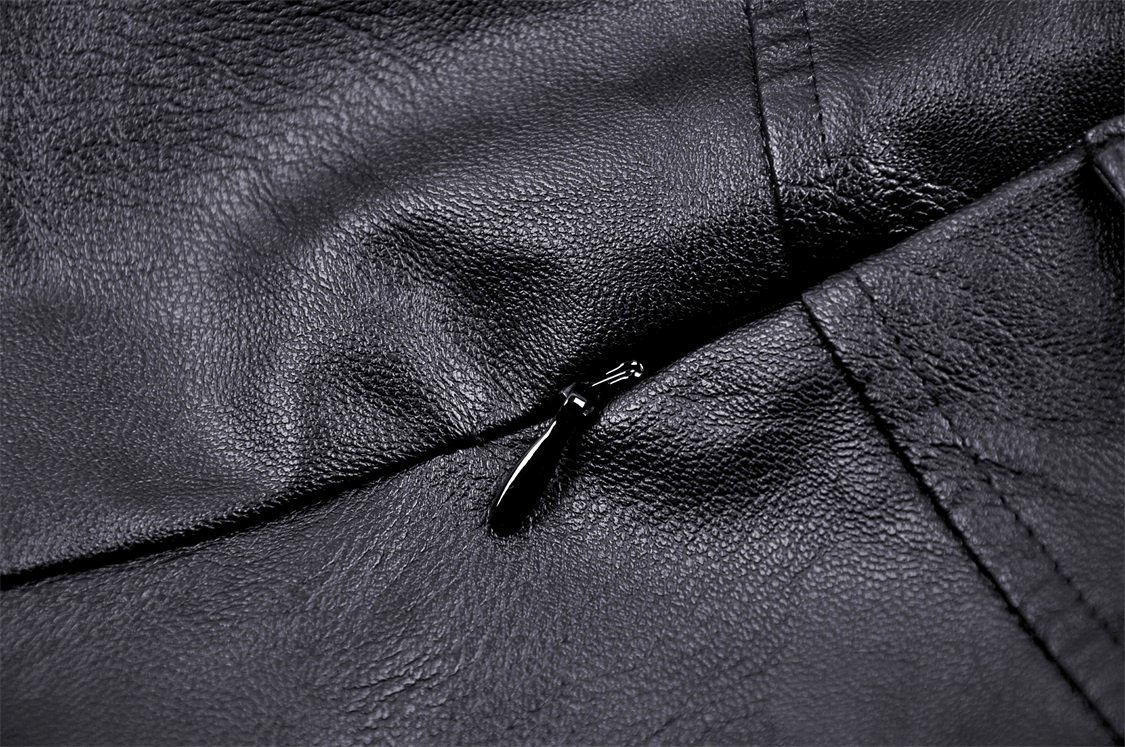 Close-up of black faux leather fabric with zipper detail, perfect for stylish gothic punk fashion.