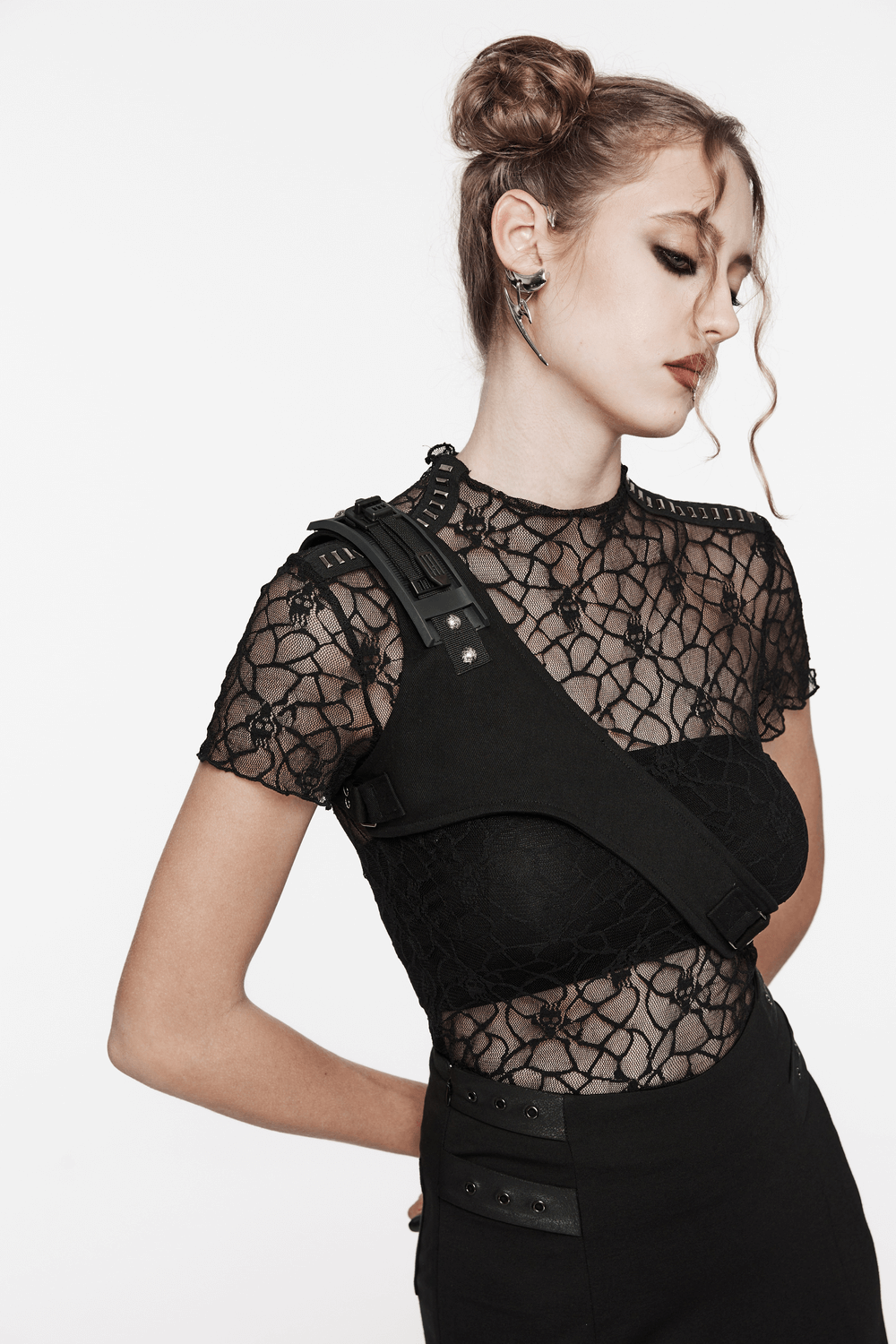 Woman wearing punk-style black micro twill O-ring chest harness with adjustable straps and lace top for a stylish edgy look.