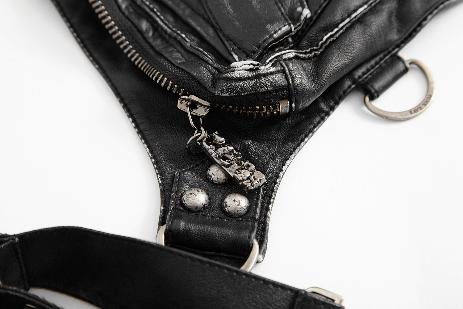 Close-up of antique silver zipper and studs on stylish black leather waist bag, showcasing its punk aesthetic.