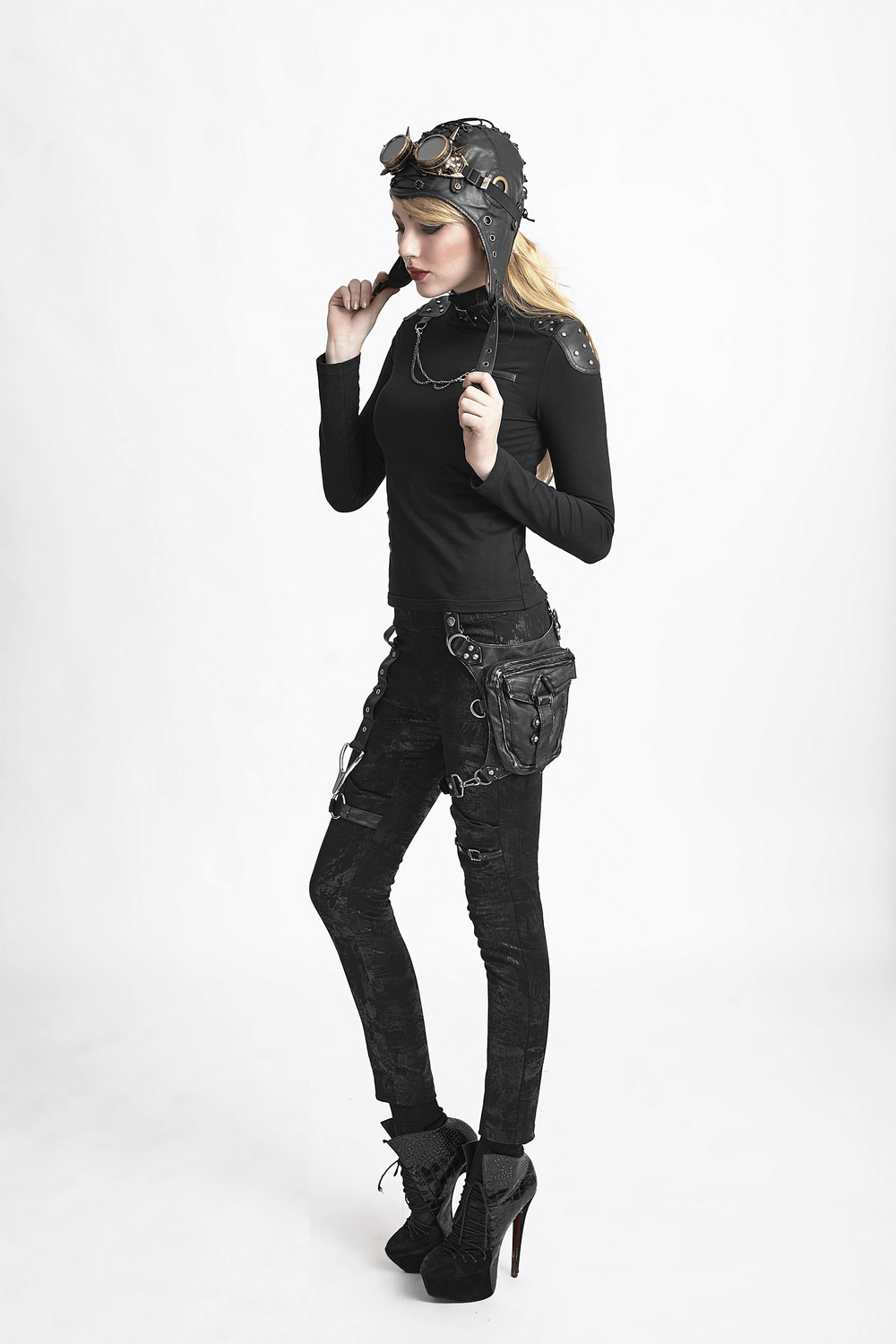 Stylish female in black leather outfit wearing a gothic waist bag with punk accessories and vintage aviator goggles.